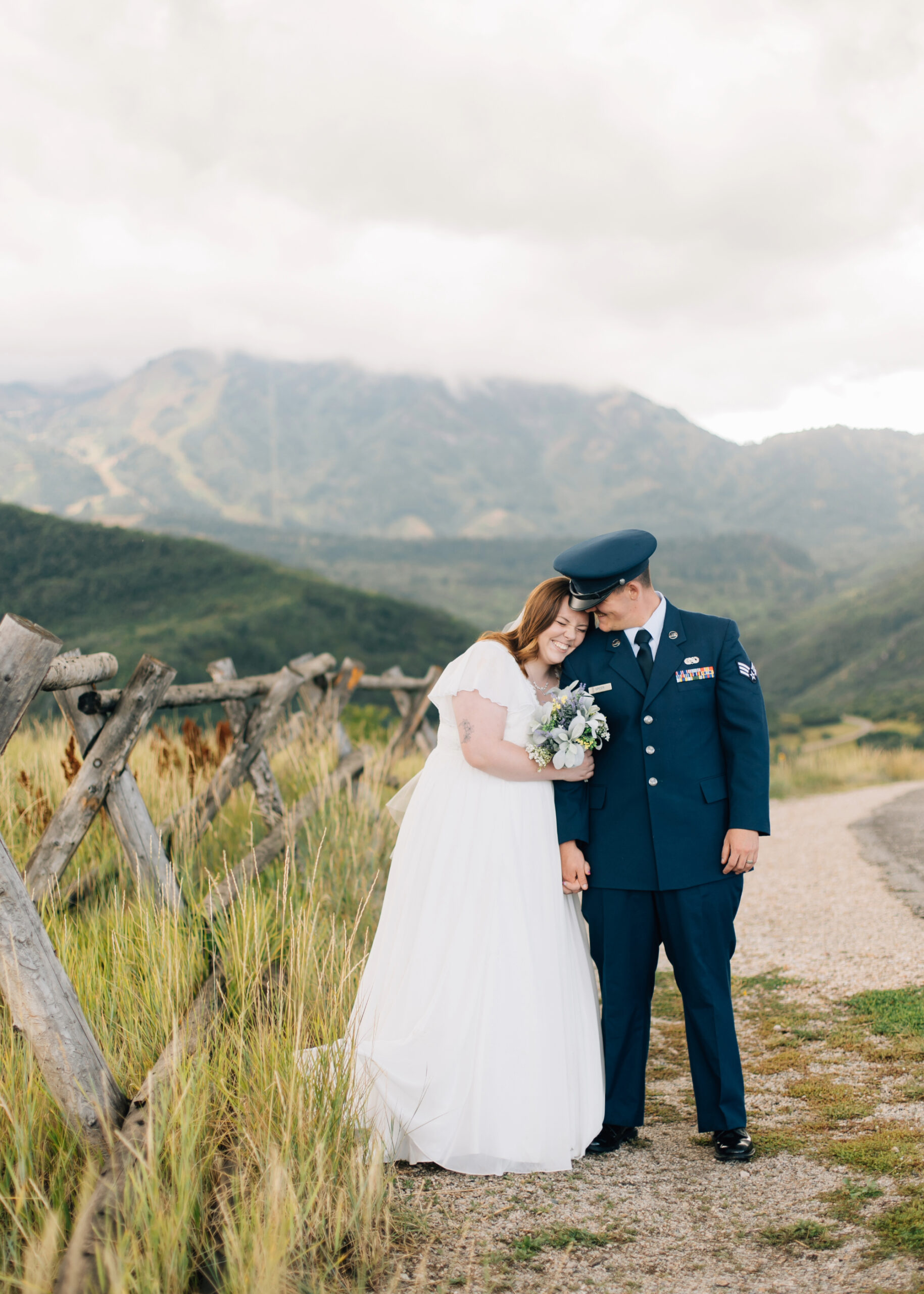 Wedding photos on a beautiful cloudy day on Old Snowbasin Road next to a wood fence